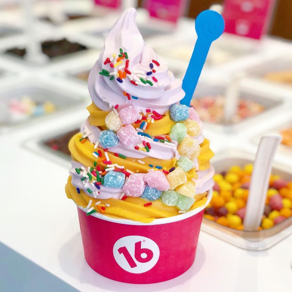 White and orange swirled mochi frozen yogurt with rainbow sprinkles in 16 Handles cup