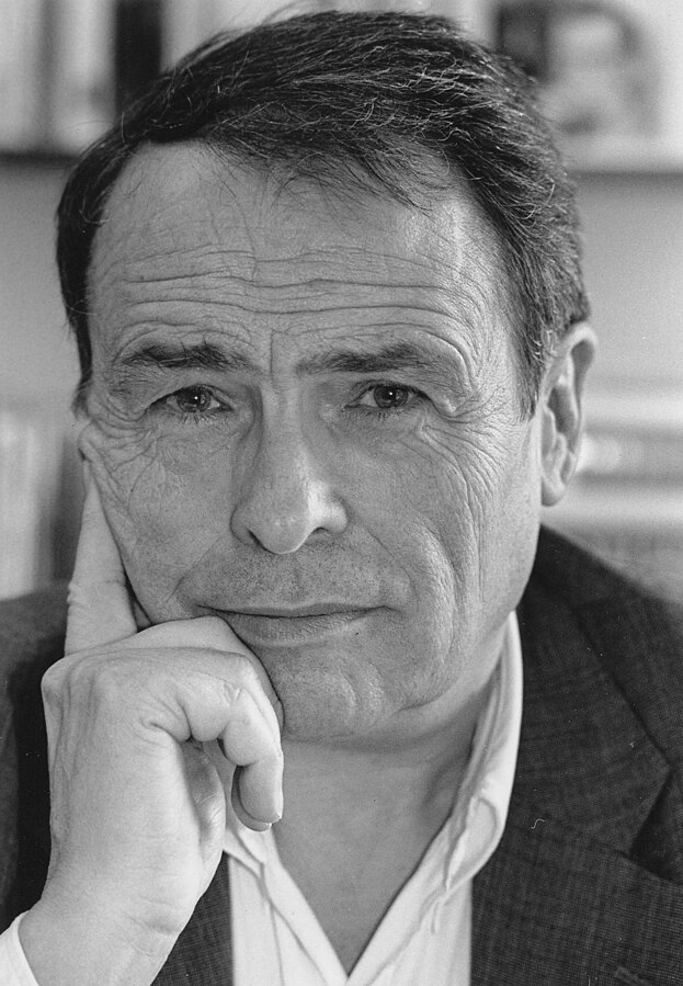 1996 black-and-white photo portrait of Pierre Bourdieu, looking into the camera with chin resting on hand