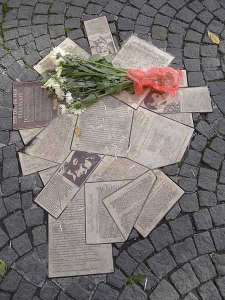 White Rose Public Memorial: Display of leaflets fanned out on ground with bouquet of white flowers on top