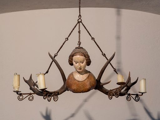 15th-century German antler chandelier featuring carving of a woman's head and shoulders in the center
