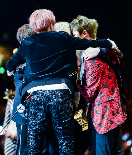 Members of K-pop group BTS hugging after winning Artist of the Year at Mnet Asian Music Awards