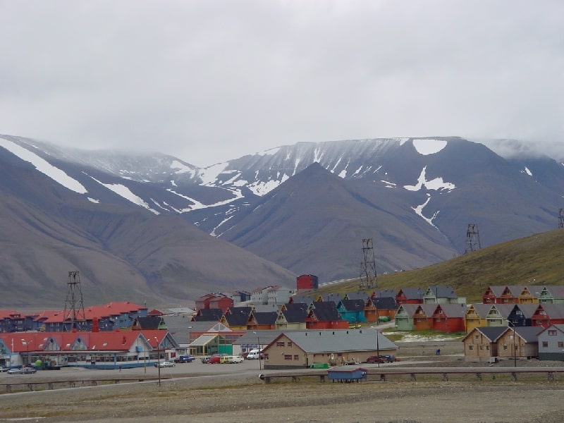 Town of Longyearbyen in Svalbard, Norway, buildings of various colors with snow-covered mountains in background