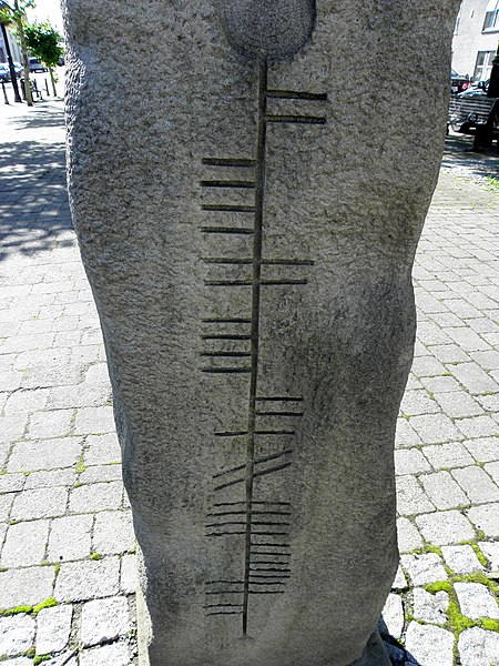 Ogham stone in Ireland, with vertical line down center and straight and diagonal lines on either side
