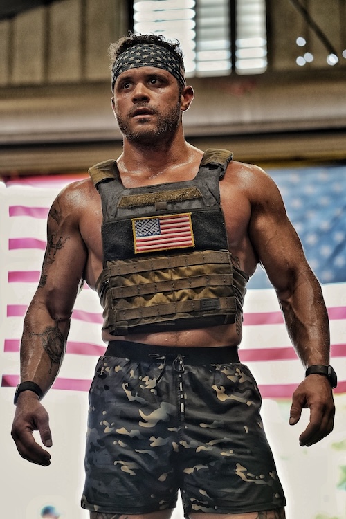 Muscular white man wearing weighted vest with American flag