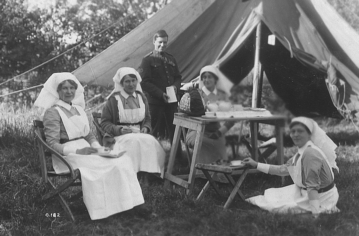 Black-and-white photo of Canadian nurses having tea in front of a tent at a Casualty Clearing Station in France, 1916