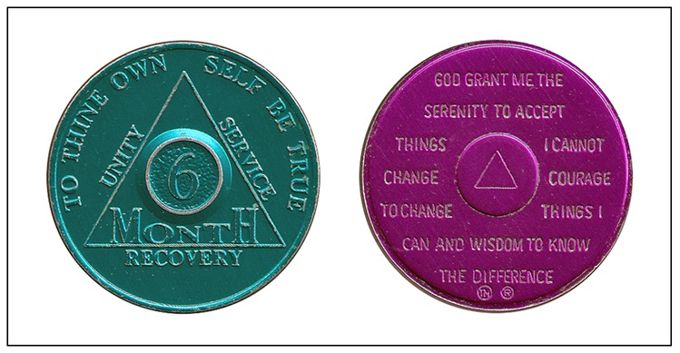 Green and purple six month sobriety chip from AA with the serenity prayer on the back