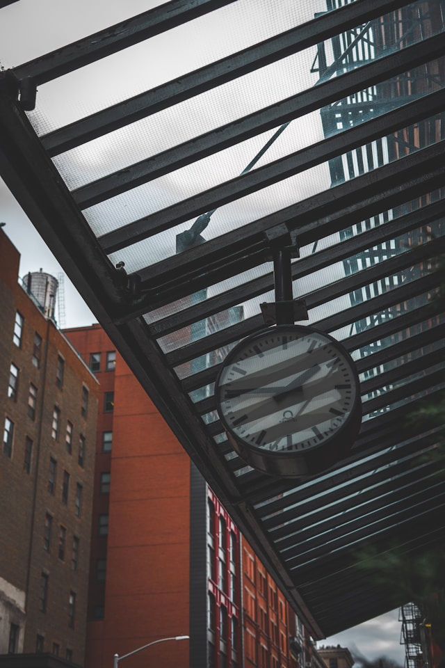 A clock seen from below through the cracks of an awning