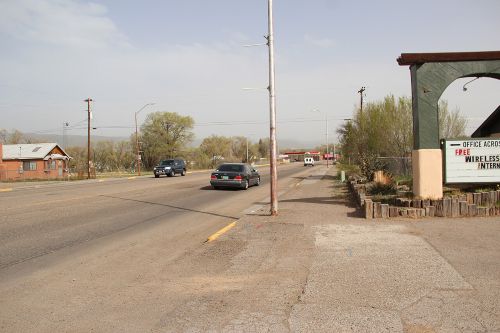 Photo taken from the side of a road with mountains visible in the background