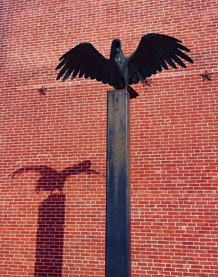 Photograph of Edgar Allan Poe National Historic Site in Philadelphia, showing statue of a raven with shadow cast against brick wall