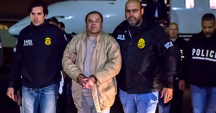 Joaquin El Chapo Guzman Loera in handcuffs flanked by US special agents