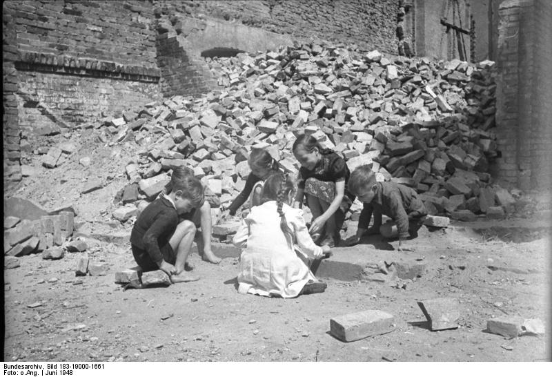 Black and white photo of children playing in rubble in Berlin in 1948