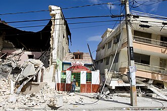 Two collapsed buildings and debris on either side of a restaurant