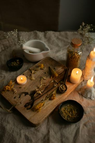 A display of candles and crushed flowers on a table
