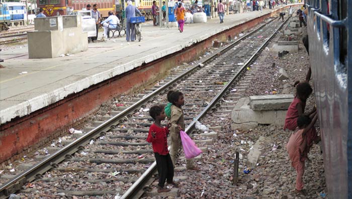 Young Indian children climbing over train tracks