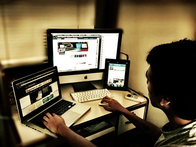 photograph of journalist surrounded by a variety of digital devices