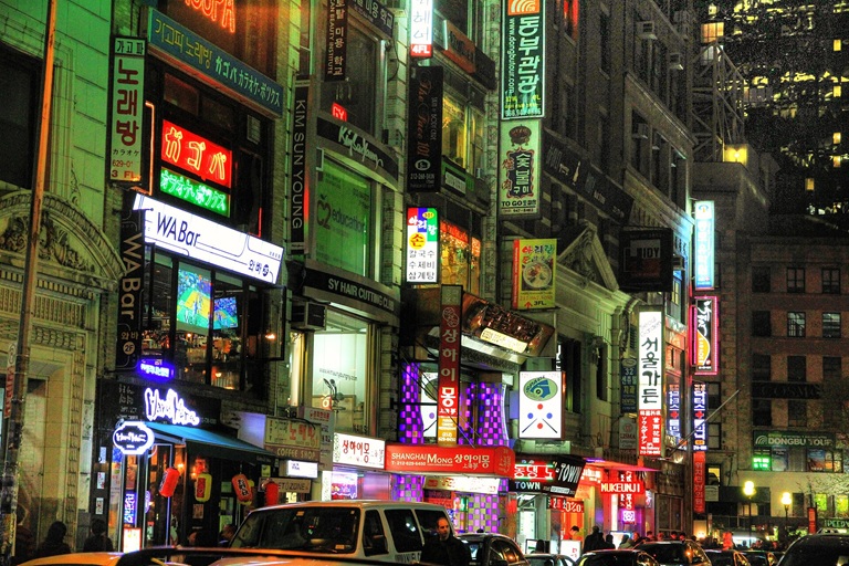 Lit up buildings at night in NYC's Koreatown with Korean words on signs
