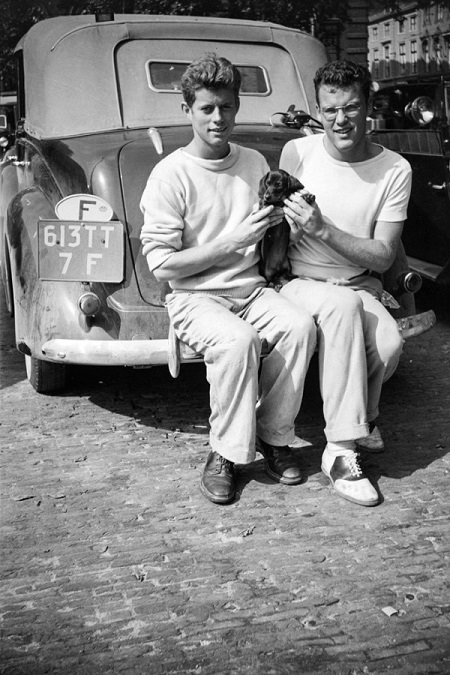 Black and white photo of JFK and Lem Billings holding a puppy in 1937