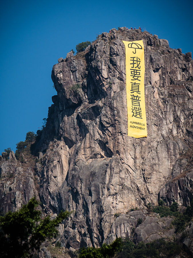 Lion Rock mountain with large yellow banner featuring Cantonese characters