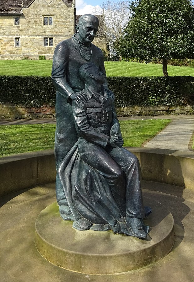 Statue depicting Archibald McIndoe standing with a seated soldier leaning against him