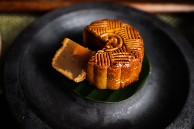 Photo of a small, round, golden-brown pastry with a triangular piece cut out