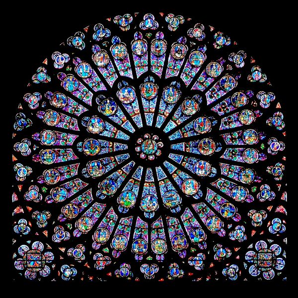 A circular stained-glass window with intricate detail, with multicolored circles fanning outward from the interior with predominant blue and purple hues