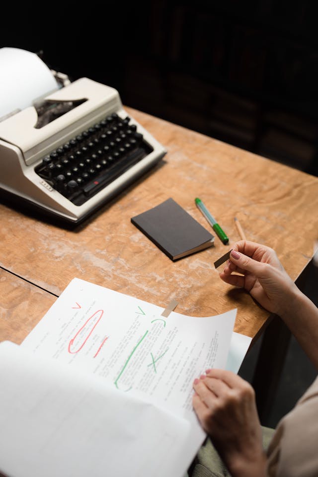 A photo of a person's hands on a desk handling papers