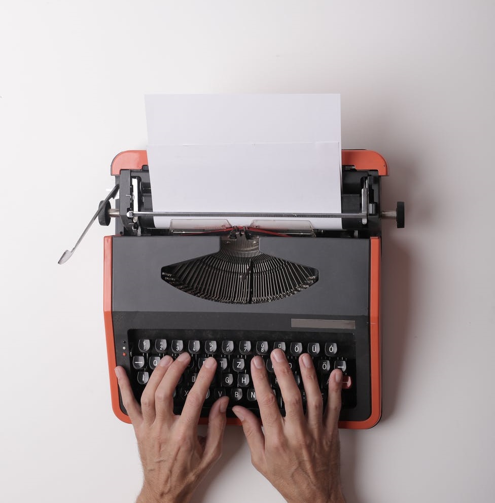 Hands poised on typewriter keys