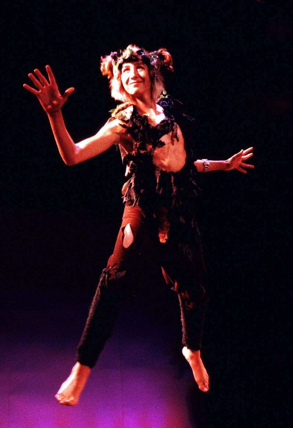 Actor Vince Cardinale starring as Puck wearing a brown and green costume featuring leaves and flowers