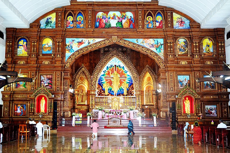 Inside of a Saint Thomas Christian church with view of an altar and wall decorated with elaborate gold and multicolored designs