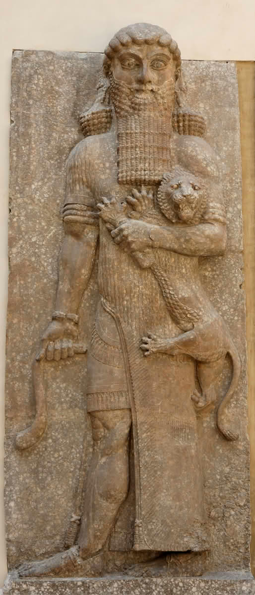 What appears to be a stone carving of Gilgamesh, holding a lion under one arm