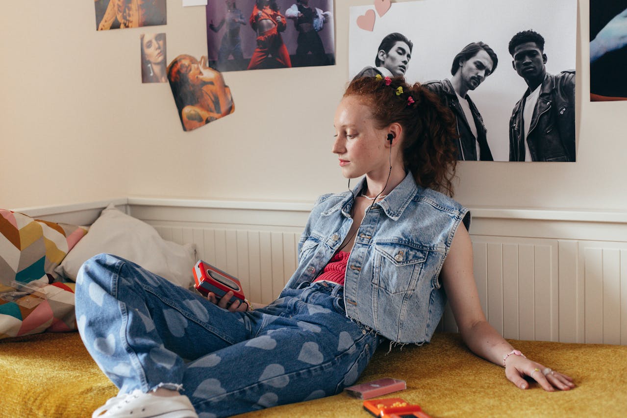 Teen girl listening to music in front of posters