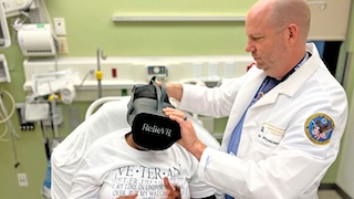 A doctor assists a patient wearing a VR headset