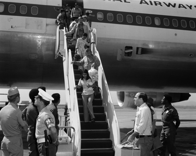 Black and white photo of refugees deboarding plane