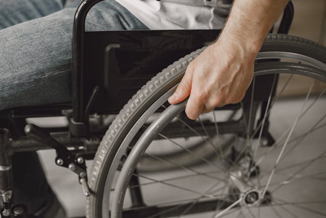 Photo of person's hand on wheel of wheelchair