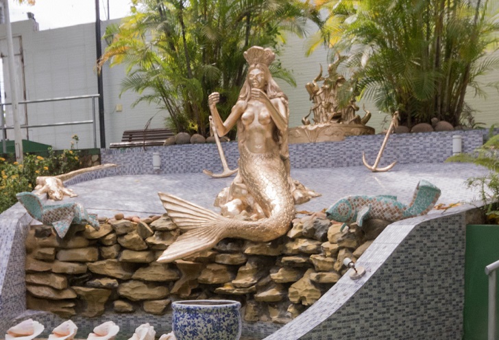 Golden statue of Yoruba deity Yemoja as a mermaid resting on rocks