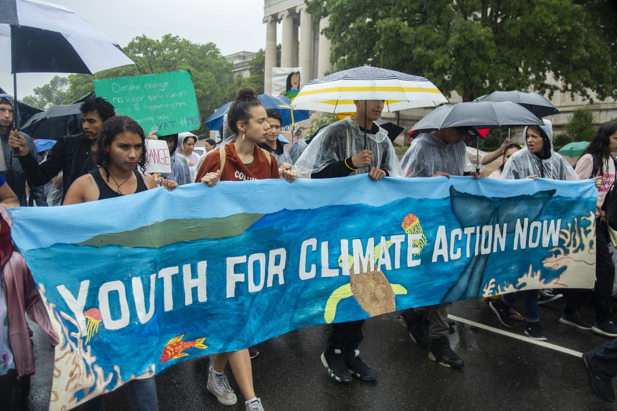 Young people marching with sign that says Youth for Climate Action Now